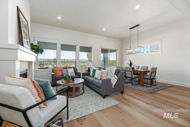 living room with light hardwood / wood-style floors and a chandelier