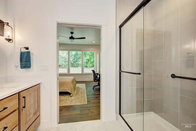 bathroom featuring a shower with door and vanity