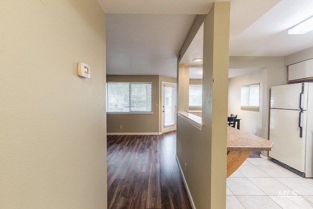 hall featuring a textured ceiling and light hardwood / wood-style flooring