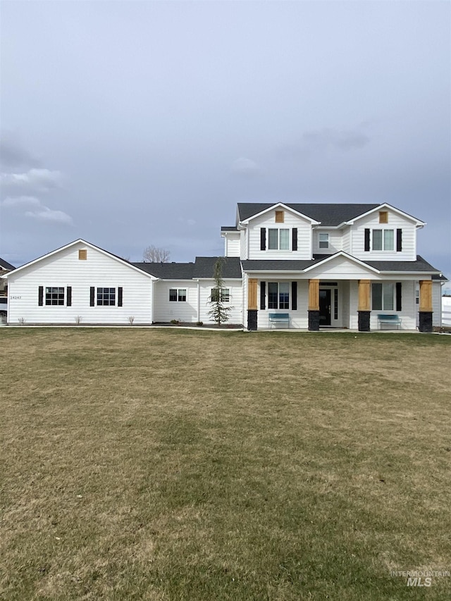 view of front of house with covered porch and a front lawn