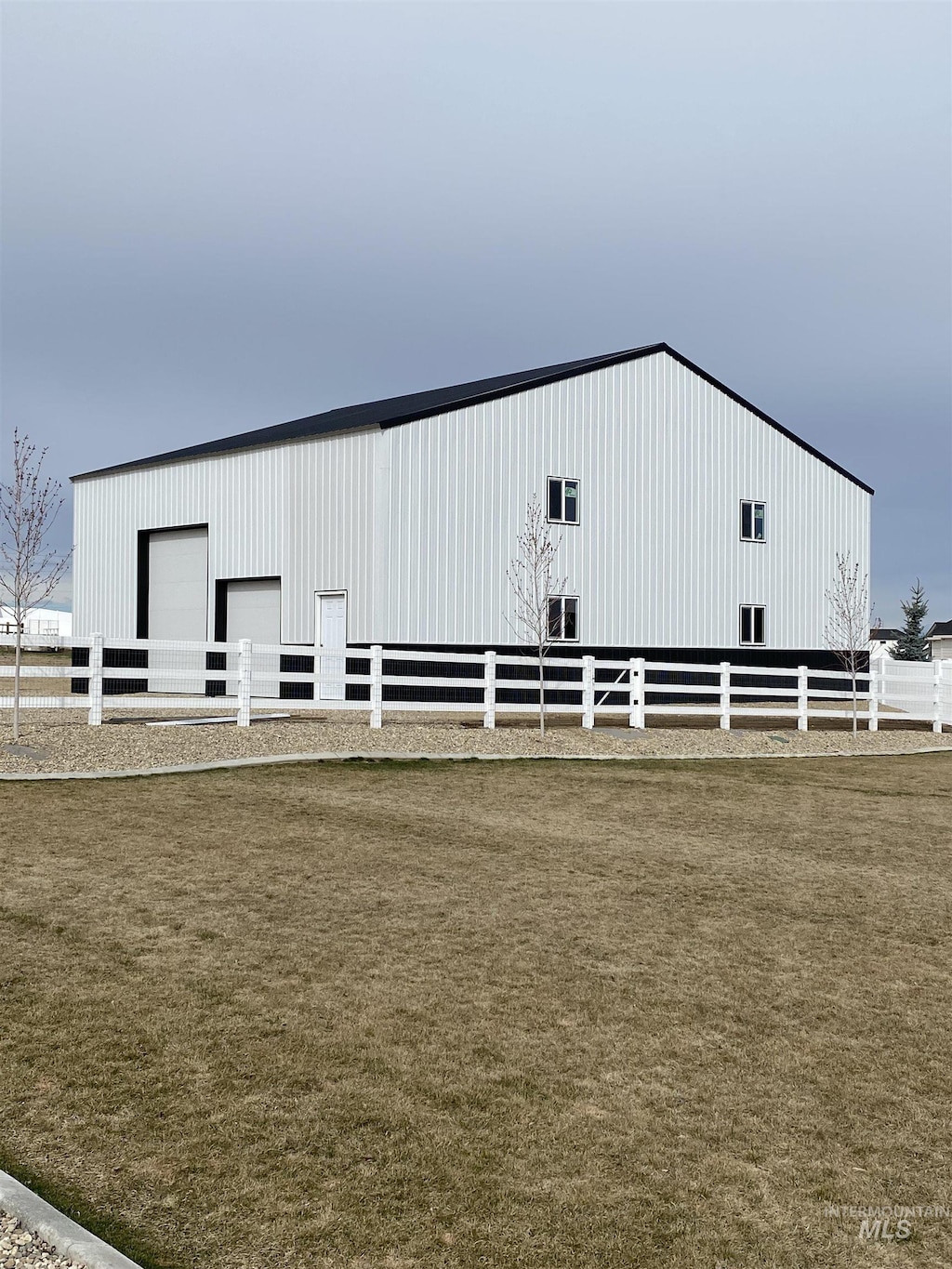 view of pole building with a yard and fence