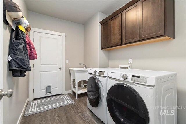 22924 Fargo Rd, Parma, ID 83660 - clothes washing area featuring baseboards, washer and dryer, cabinet space, and dark wood-style flooring