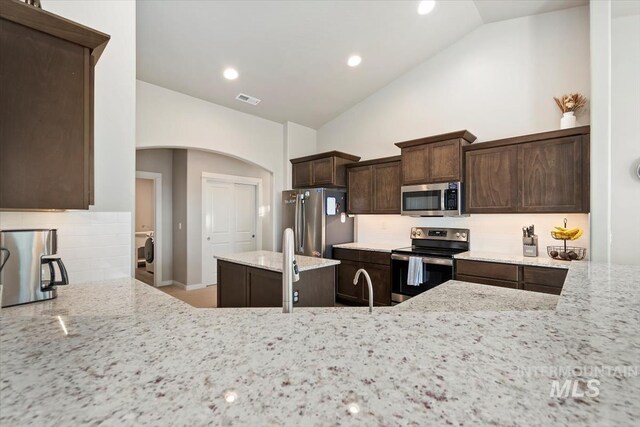 22924 Fargo Rd, Parma, ID 83660 - kitchen with light stone counters, tasteful backsplash, stainless steel appliances, visible vents, and dark brown cabinets