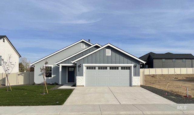 323 W Omphale St, Kuna, ID 83634 - view of front facade featuring board and batten siding, an attached garage, concrete driveway, and stone siding