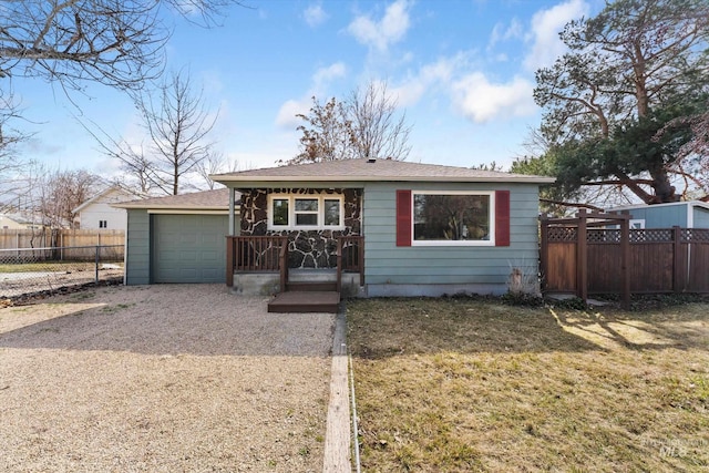 view of front of home with a front yard, an attached garage, fence, and driveway