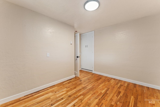 empty room with baseboards and light wood finished floors