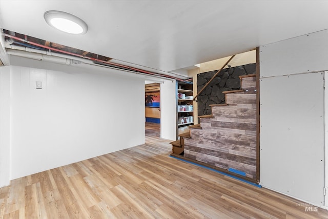 finished basement with stairs and wood finished floors