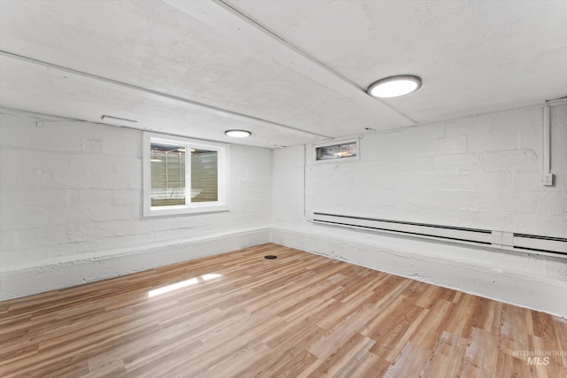 below grade area with wood finished floors and baseboard heating