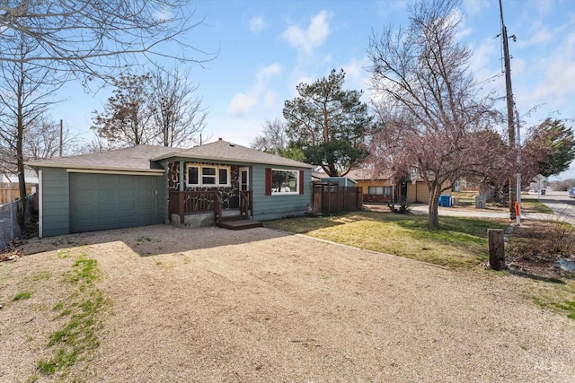 view of front of property featuring dirt driveway, an attached garage, a shingled roof, and fence