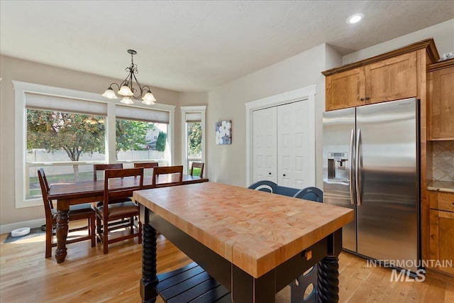 dining room featuring a chandelier, light wood finished floors, baseboards, and recessed lighting