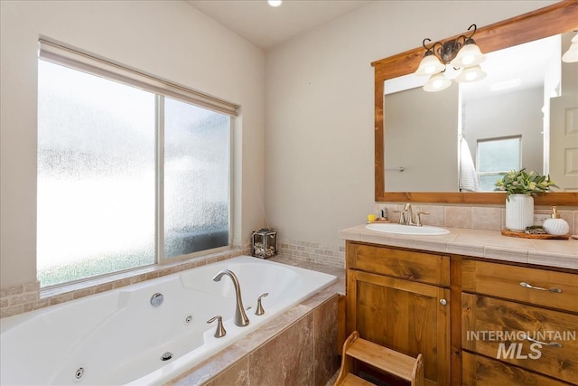 full bathroom with a whirlpool tub, plenty of natural light, and vanity