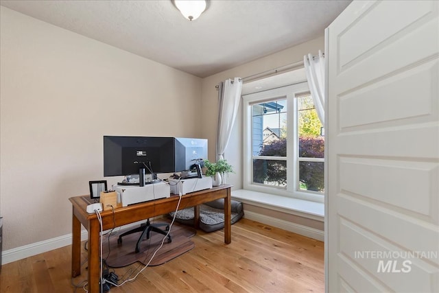 home office with baseboards and wood finished floors