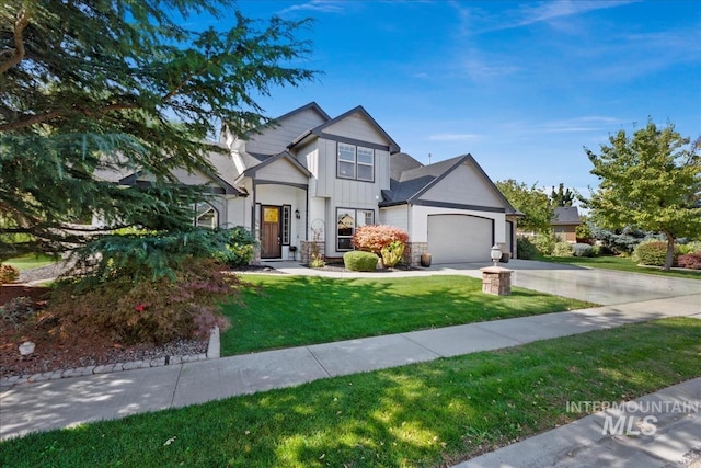 view of front facade featuring board and batten siding, a front yard, driveway, and an attached garage