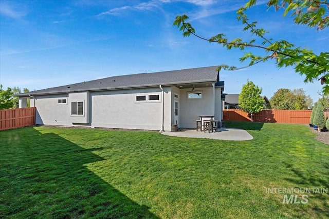 back of property with a lawn, a fenced backyard, a patio area, and stucco siding