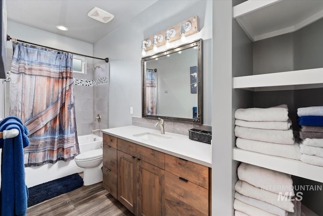 bathroom featuring tasteful backsplash, wood finished floors, vanity, toilet, and shower / bathtub combination with curtain