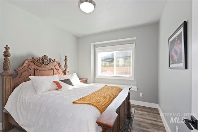 bedroom featuring baseboards and dark wood-style floors
