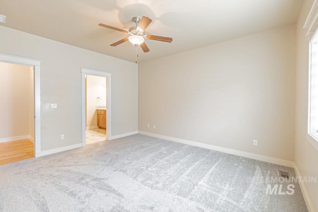 7053 W Butte Ln, Boise, ID 83704 - unfurnished bedroom with light carpet, baseboards, ensuite bath, and a ceiling fan