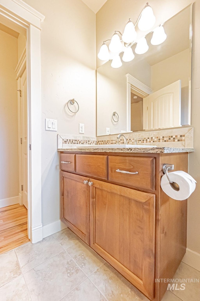 7053 W Butte Ln, Boise, ID 83704 - bathroom featuring vanity, baseboards, tile patterned floors, and a chandelier