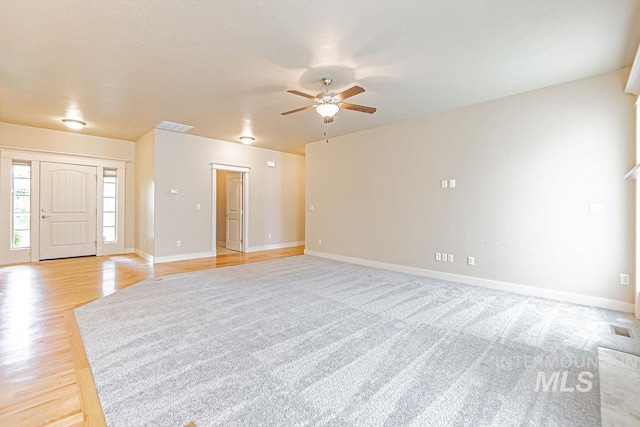 7053 W Butte Ln, Boise, ID 83704 - unfurnished living room with ceiling fan, baseboards, and light wood-type flooring