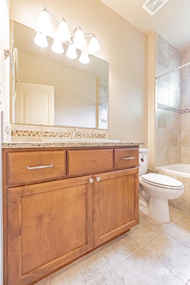 7053 W Butte Ln, Boise, ID 83704 - full bath with vanity, toilet, tile patterned floors, tiled shower / bath combo, and tasteful backsplash