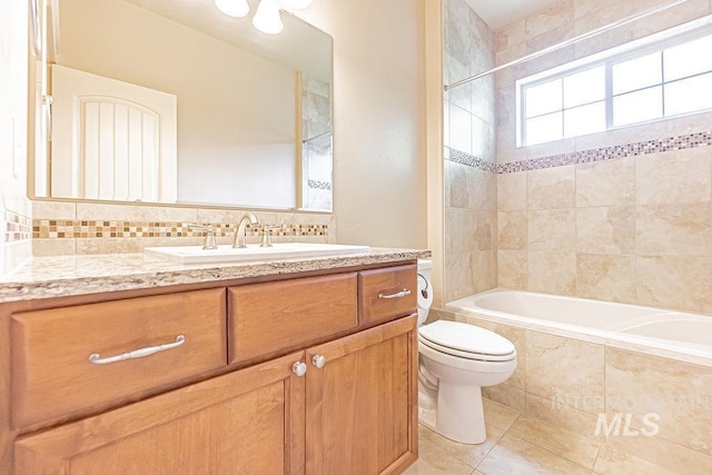 7053 W Butte Ln, Boise, ID 83704 - bathroom featuring tile patterned flooring, vanity, tiled shower / bath, and toilet