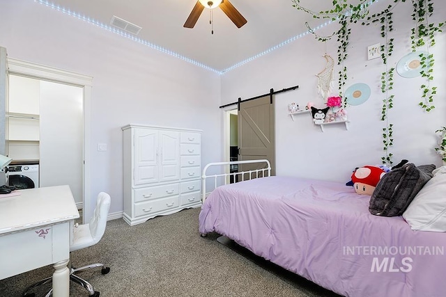 carpeted bedroom featuring a barn door and ceiling fan