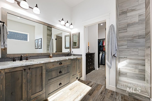 bathroom with vanity, wood-type flooring, and a tile shower