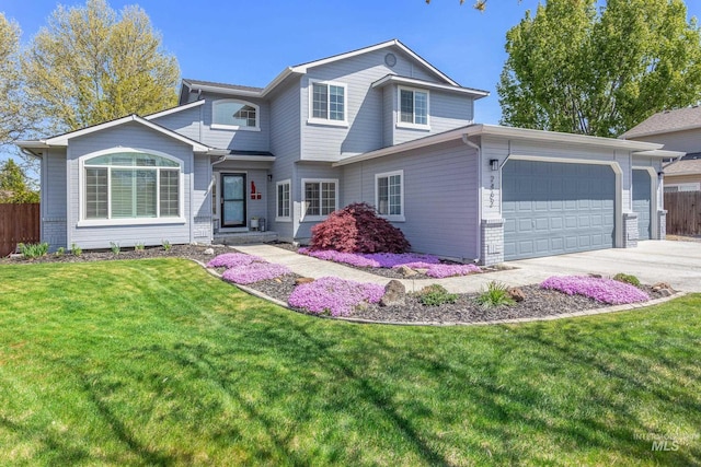 traditional-style home with fence, an attached garage, concrete driveway, and a front lawn