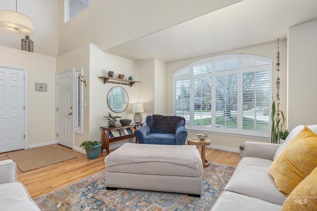 living area featuring plenty of natural light, baseboards, wood finished floors, and visible vents