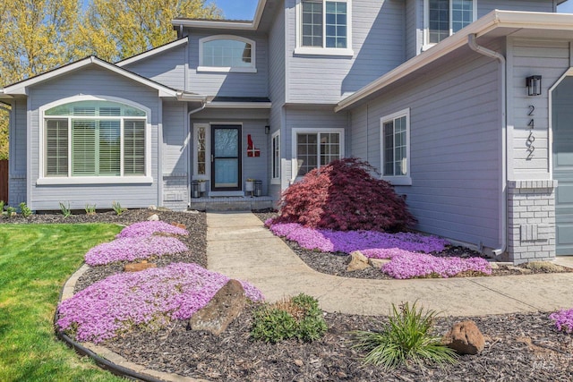view of exterior entry with a lawn