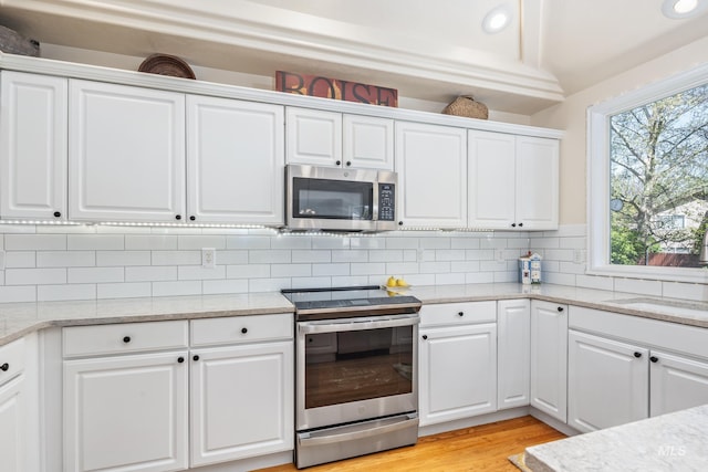 kitchen featuring light wood-style flooring, appliances with stainless steel finishes, and white cabinets