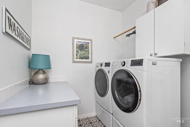 laundry area with baseboards, cabinet space, and washer and dryer