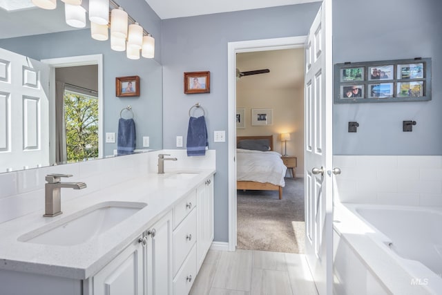 ensuite bathroom with a sink, ensuite bathroom, a garden tub, and double vanity