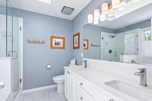 bathroom featuring baseboards, a sink, toilet, and a shower stall