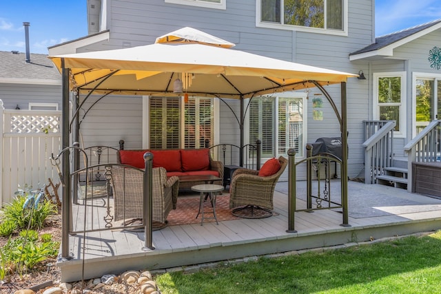 wooden terrace featuring fence, a gazebo, and an outdoor living space