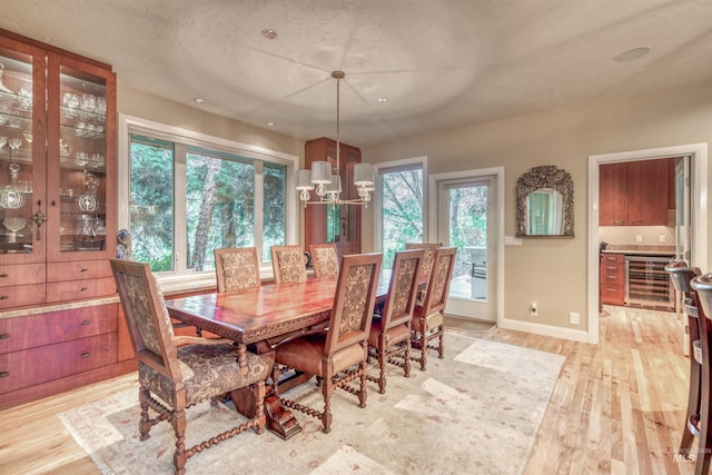 705 N Cobblestone Way, Eagle, ID 83616 - dining space with wine cooler, light wood-style flooring, a chandelier, and baseboards
