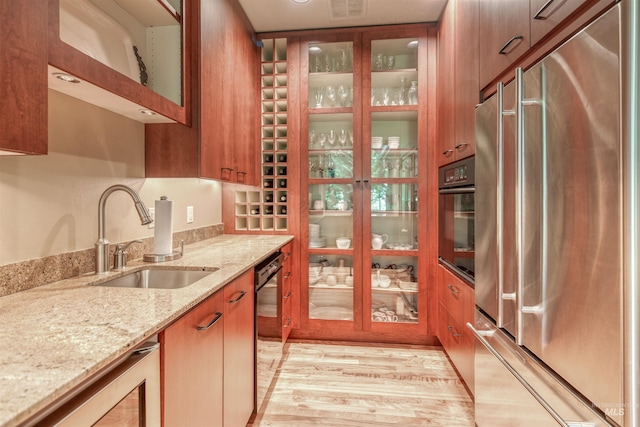 705 N Cobblestone Way, Eagle, ID 83616 - kitchen with black appliances, a sink, beverage cooler, brown cabinets, and light stone countertops
