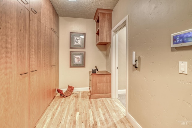 705 N Cobblestone Way, Eagle, ID 83616 - hallway with light wood-style flooring, a textured ceiling, and baseboards