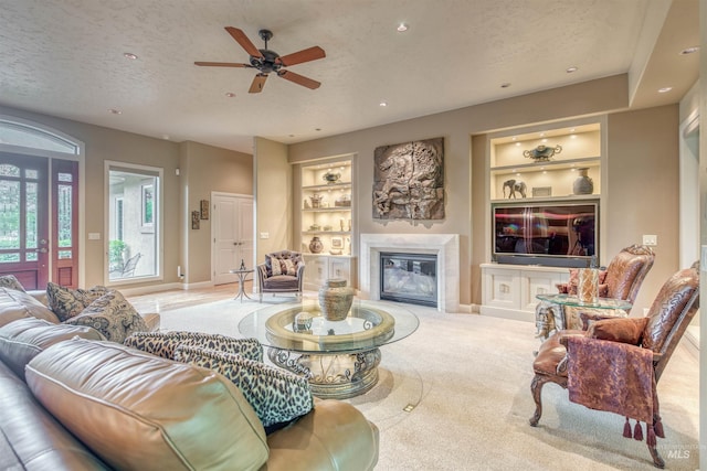 705 N Cobblestone Way, Eagle, ID 83616 - living area with built in shelves, a textured ceiling, a glass covered fireplace, baseboards, and a ceiling fan