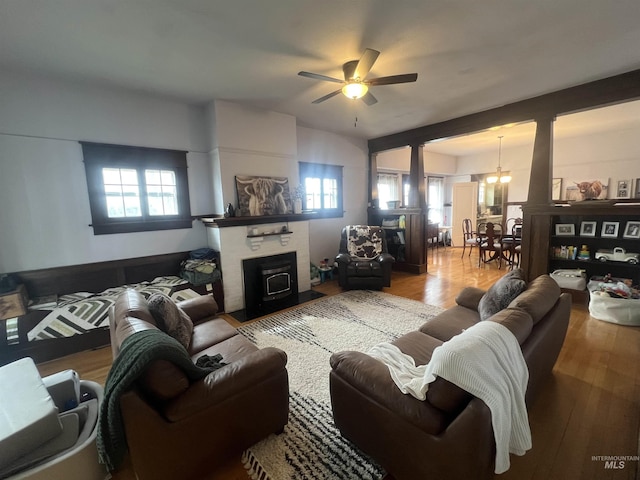 living room with a fireplace with flush hearth, ceiling fan with notable chandelier, plenty of natural light, and wood finished floors