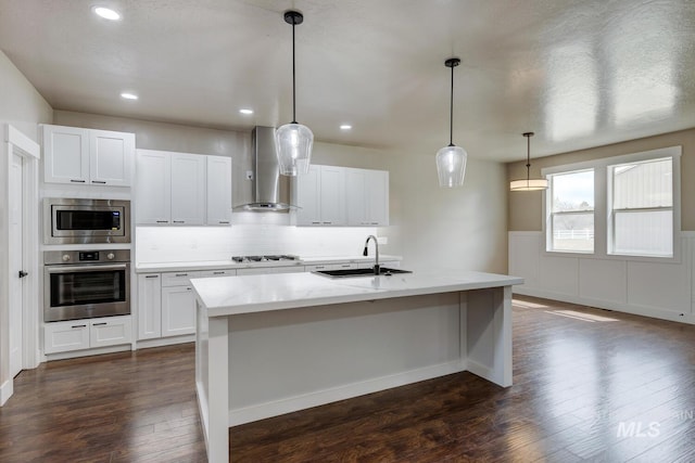 1113 W Blaine Ave, Nampa, ID 83651 - kitchen featuring dark wood finished floors, tasteful backsplash, wall chimney range hood, a sink, and stainless steel appliances