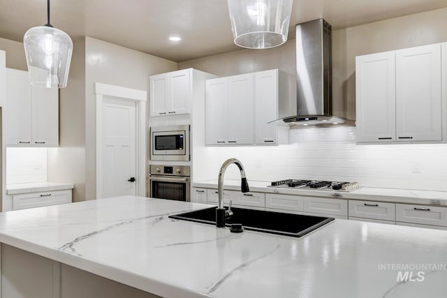 1113 W Blaine Ave, Nampa, ID 83651 - kitchen with tasteful backsplash, white cabinets, wall chimney exhaust hood, a sink, and stainless steel appliances