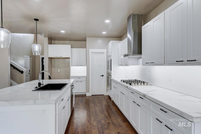1113 W Blaine Ave, Nampa, ID 83651 - kitchen featuring an island with sink, wall chimney range hood, appliances with stainless steel finishes, dark wood-style flooring, and a sink
