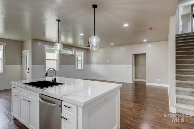 1113 W Blaine Ave, Nampa, ID 83651 - kitchen with dark wood-style flooring, a wainscoted wall, white cabinets, a kitchen island with sink, and a sink