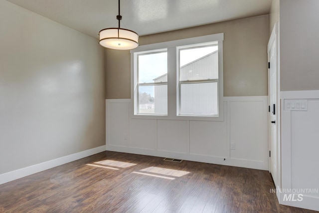 1113 W Blaine Ave, Nampa, ID 83651 - spare room featuring dark wood-type flooring, wainscoting, and visible vents