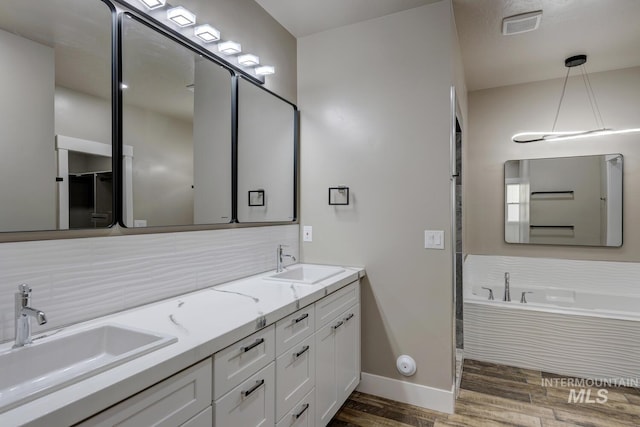 1113 W Blaine Ave, Nampa, ID 83651 - bathroom with a sink, tasteful backsplash, wood finished floors, and baseboards