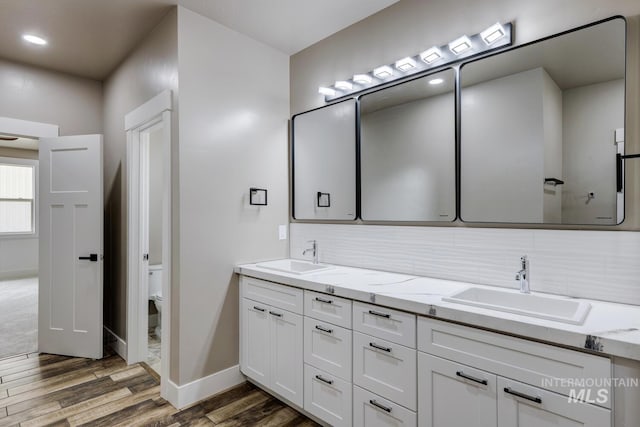 1113 W Blaine Ave, Nampa, ID 83651 - bathroom featuring a sink, decorative backsplash, and wood finished floors