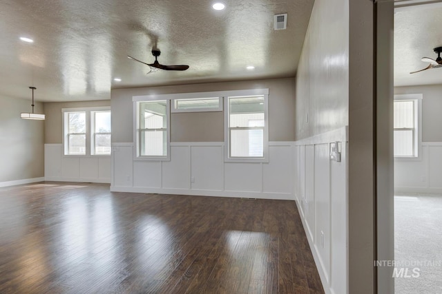 1113 W Blaine Ave, Nampa, ID 83651 - empty room with a textured ceiling, wood finished floors, ceiling fan, and a wainscoted wall