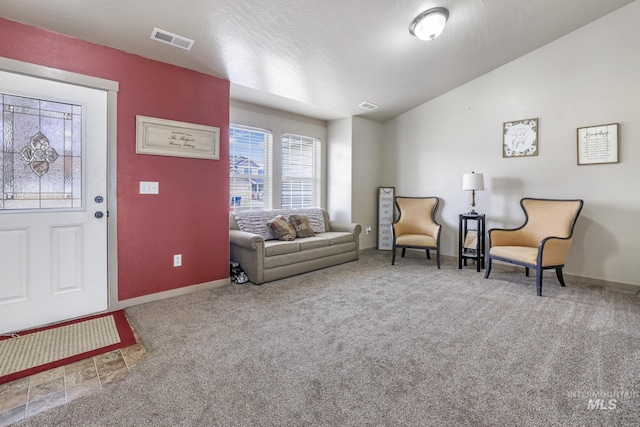 living area featuring vaulted ceiling, carpet, visible vents, and baseboards