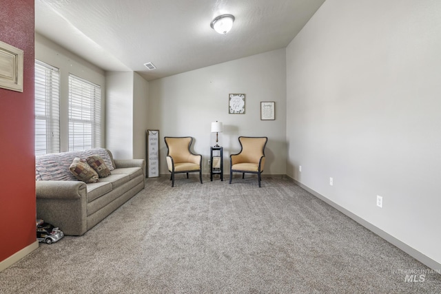 sitting room featuring lofted ceiling, carpet flooring, visible vents, and baseboards